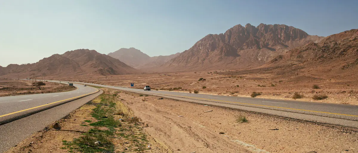 مواقيت الصلاة في معان: طريق صحراوي بين جبال صخرية في جنوب الأردن