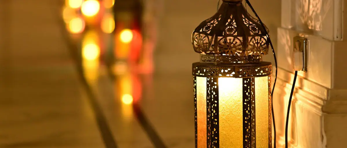 إمساكية رمضان 1448: فانوس رمضان مضاء على أرضية رخامية، وخلفه فوانيس ملونة