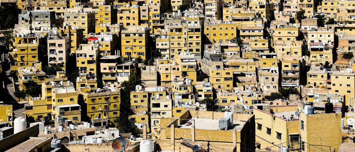 شروط الاستخدام: بيوت عمّان المتلاصقة على سفح جبل في يوم مشمس